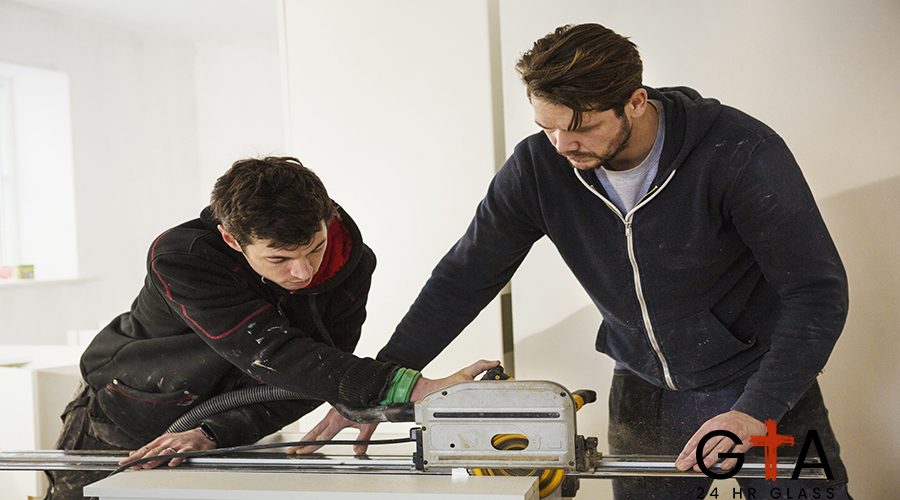 Two builders, cutting plasterboard with a circular saw.