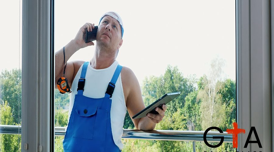 attractive Construction worker is discussing something on the phone, makes measurements of windows, makes notes in tablet. service man , builder examines the object. High quality photo