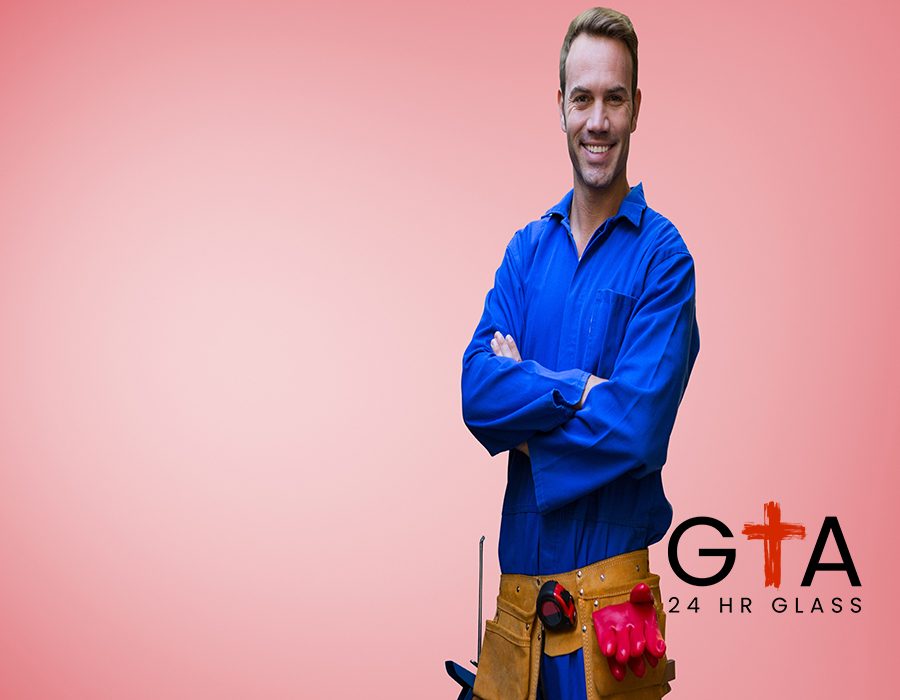 Portrait of handyman with tool belt standing with arms crossed against red background