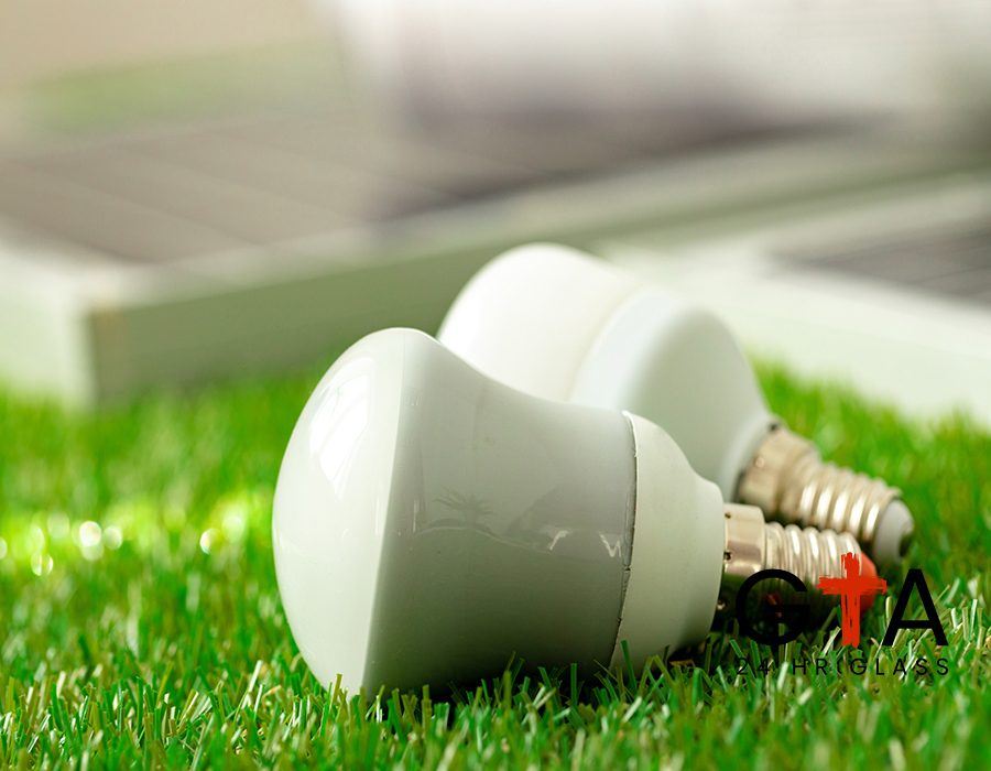 Energy efficient light bulb lying on grass close up