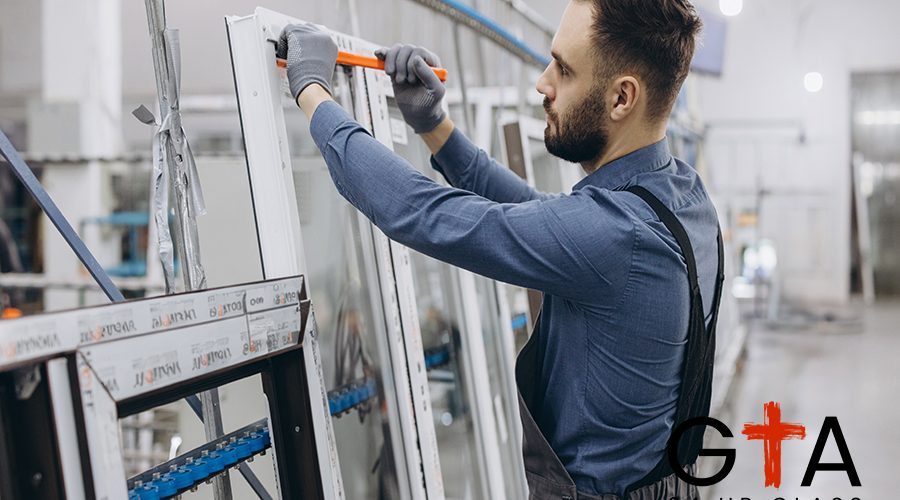 Factory worker wearing uniform and gloves using ruler to measure PVC window frame in production line of aluminum and PVC windows and doors factory