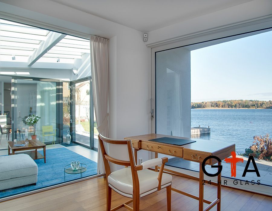 A luxury beach house with glass windows and the beautiful scenery of the sea in the background